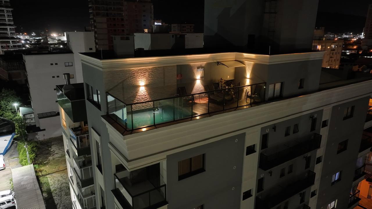 Bell Mare Residenza — área de lazer do rooftop à noite, com vista da cidade